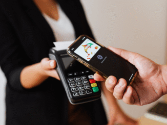 Pessoa realizando pagamento por aproximação usando smartphone em máquina de cartão