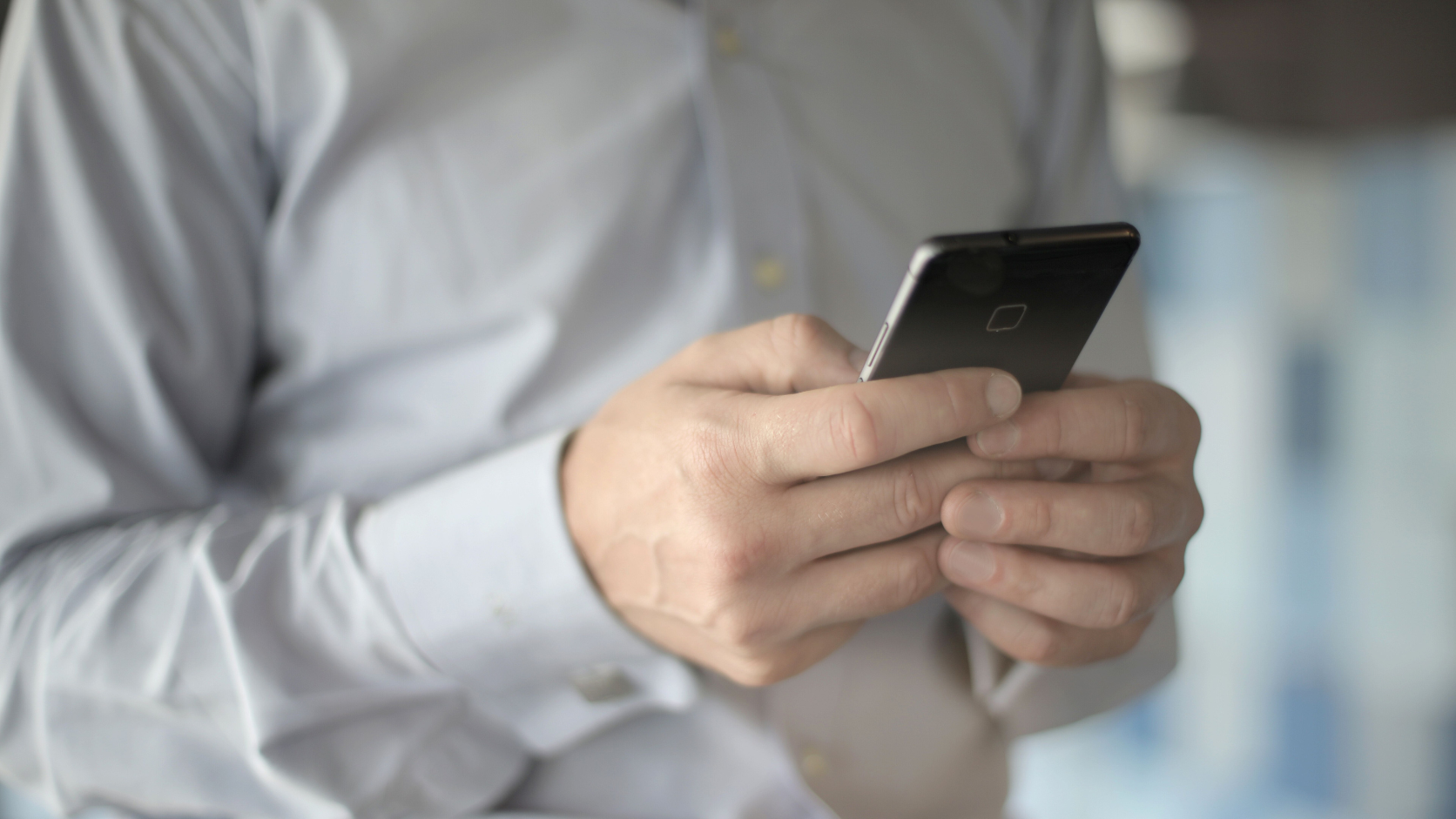 Pessoa utilizando um celular para visualizar e assinar um documento em PDF.