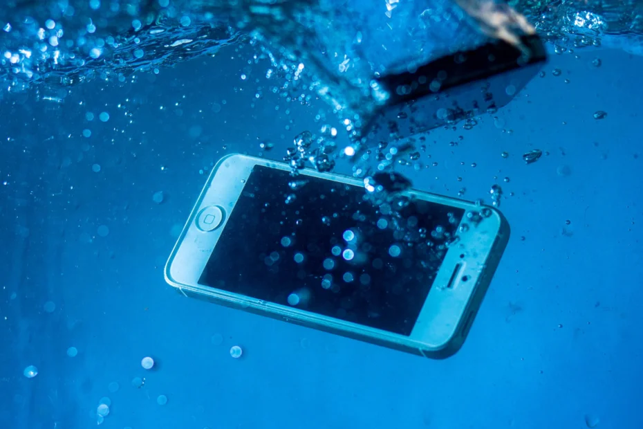 Celular molhado mostrando a resistência à água e a certificação IP67 ou IP68.