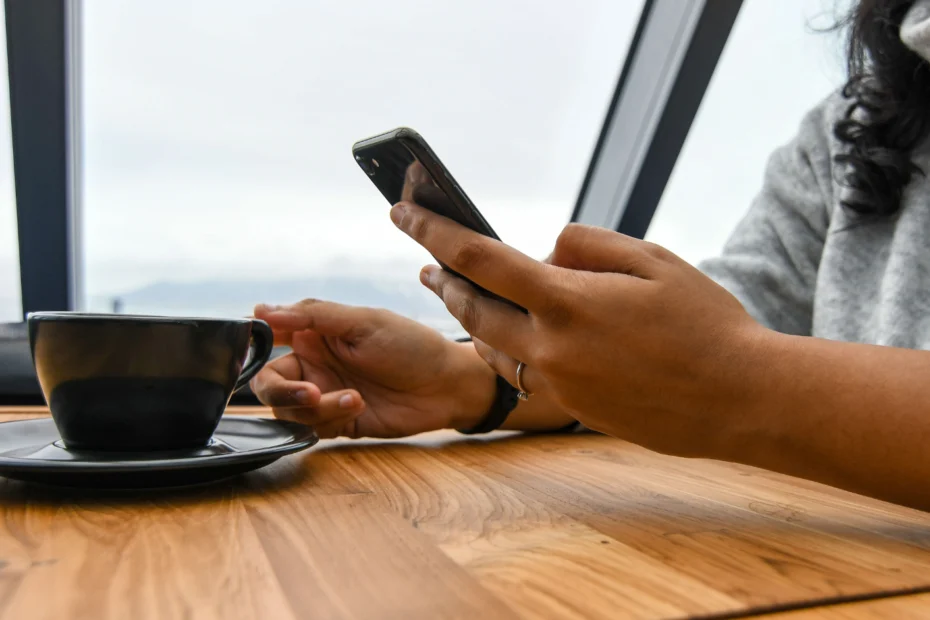 Pessoa usando o celular conectada a uma rede Wi-Fi pública em uma cafeteria.