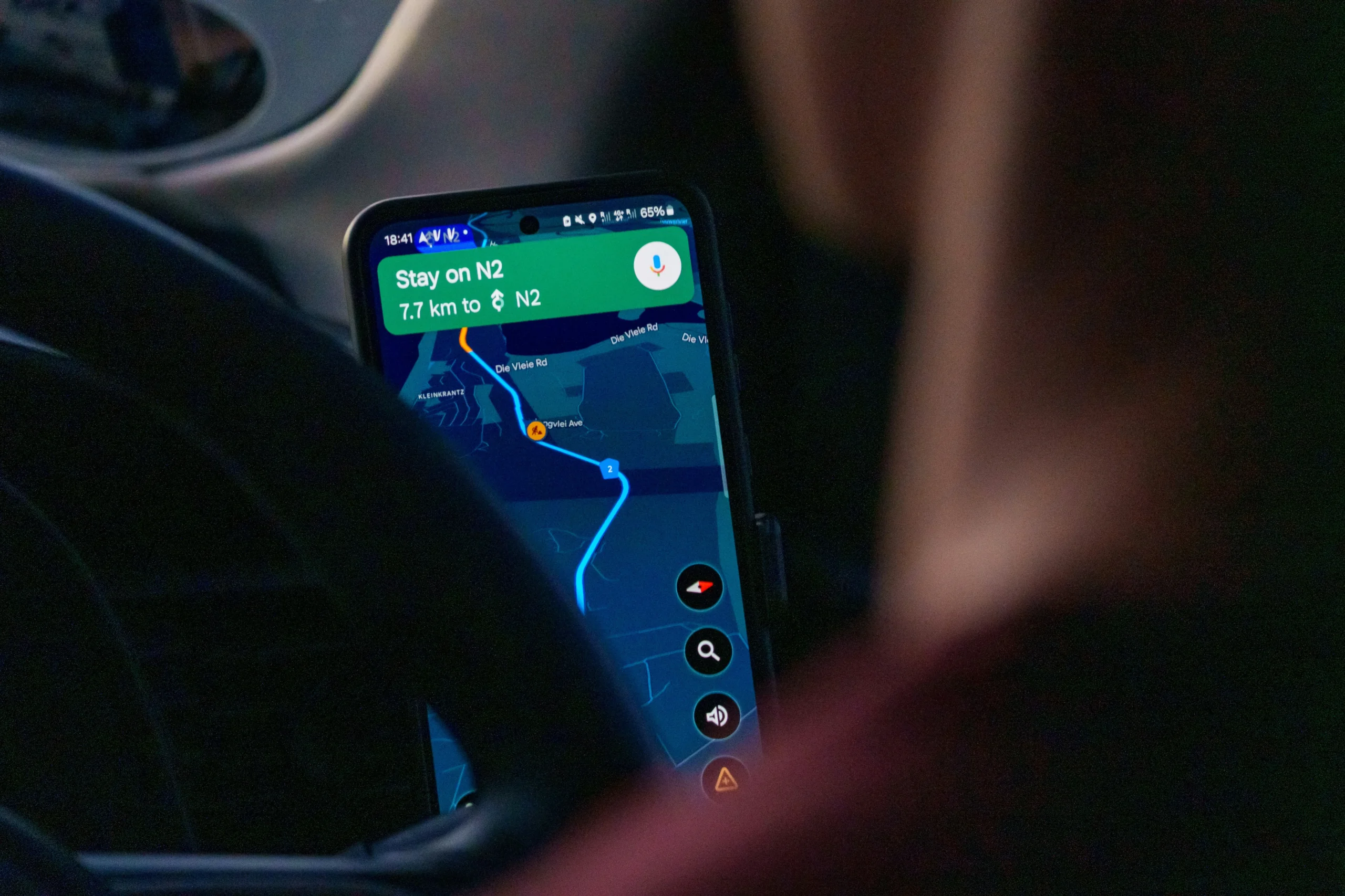 Smartphone conectado via cabo USB ao painel central de um carro executando espelhamento de tela