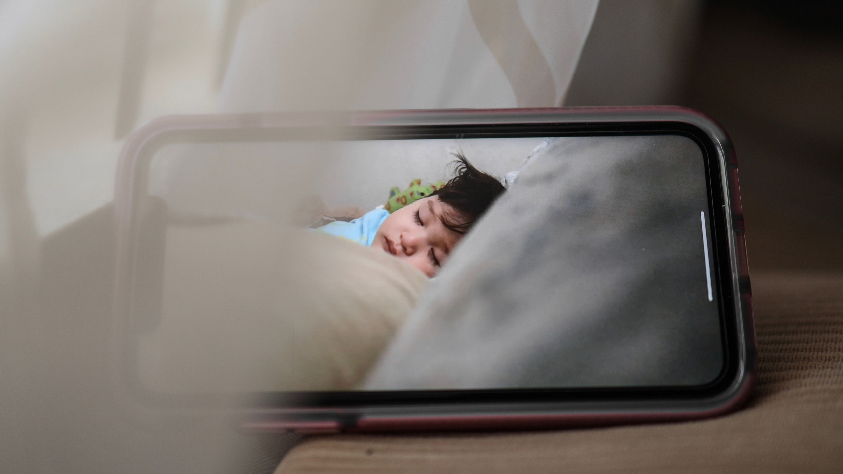 Celular antigo posicionado para monitoramento remoto funcionando como câmera de segurança e babá eletrônica.