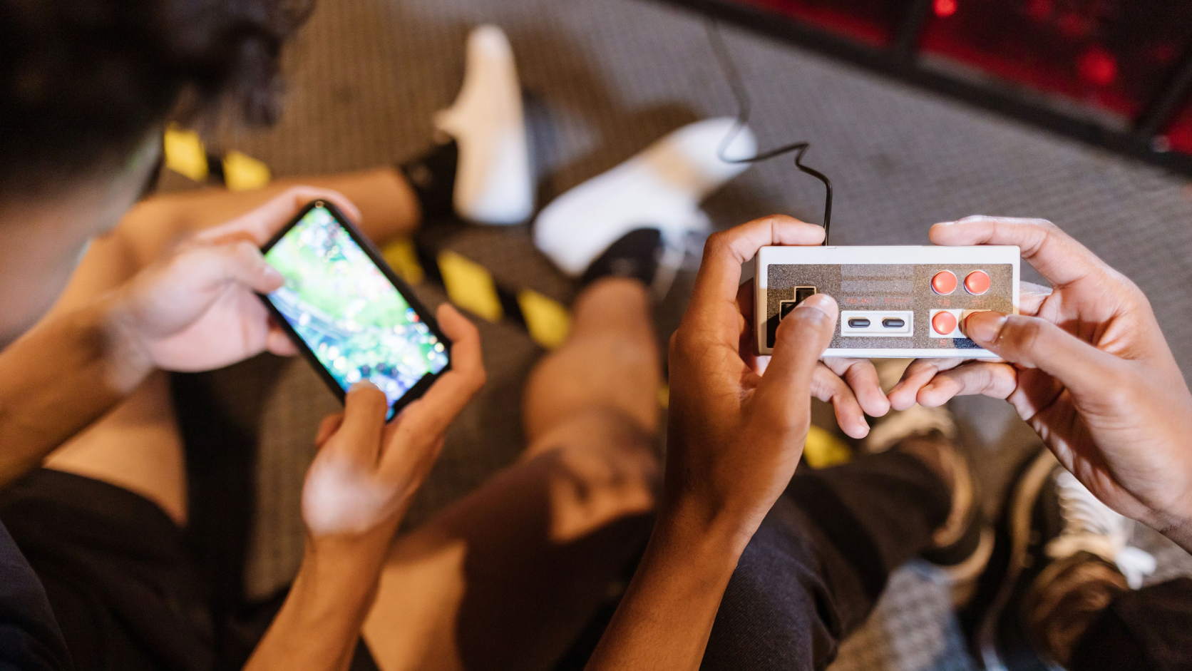 Smartphone antigo acoplado a um controle gamepad Bluetooth rodando jogos retrô.